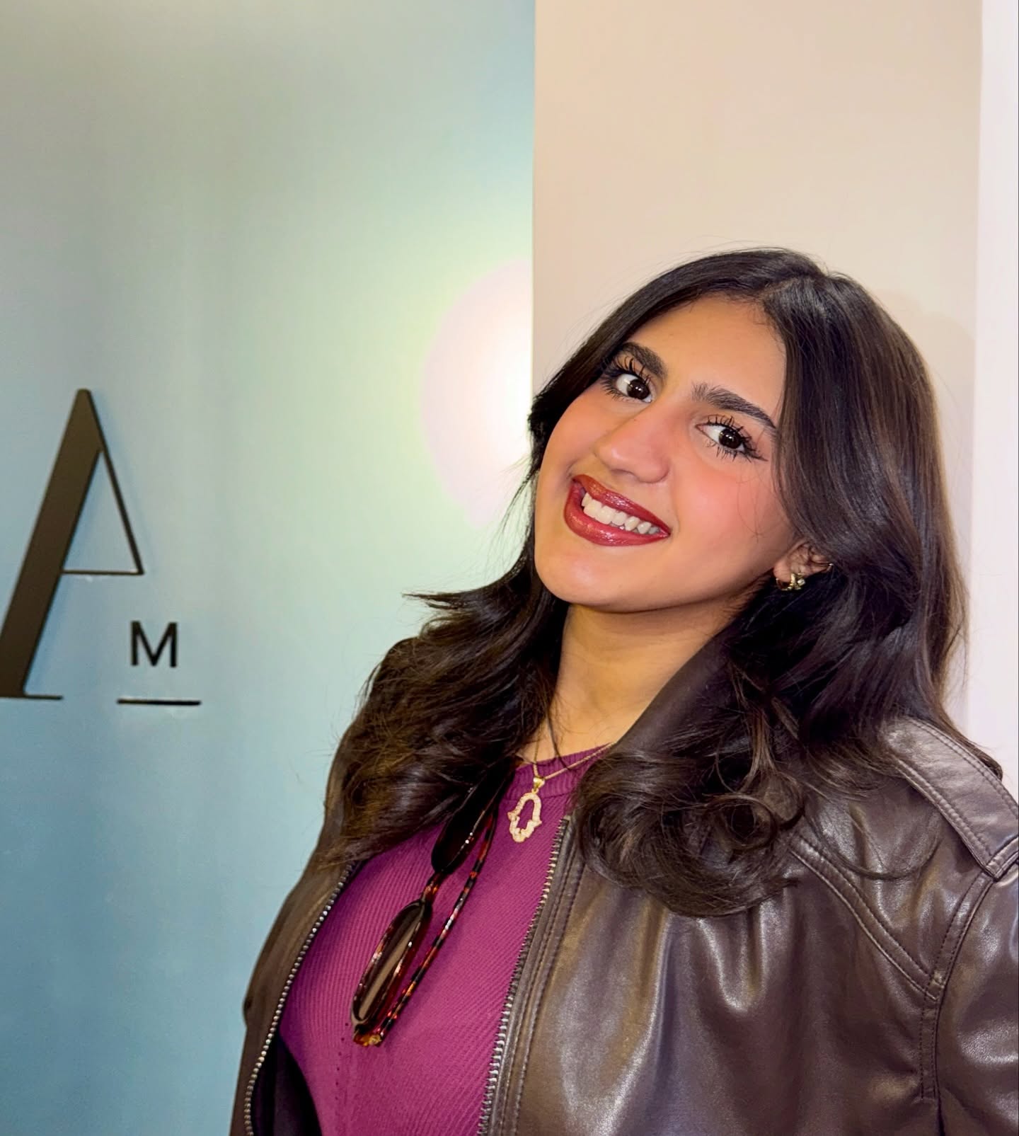 Patiente souriante devant le logo A/M Dental Center
